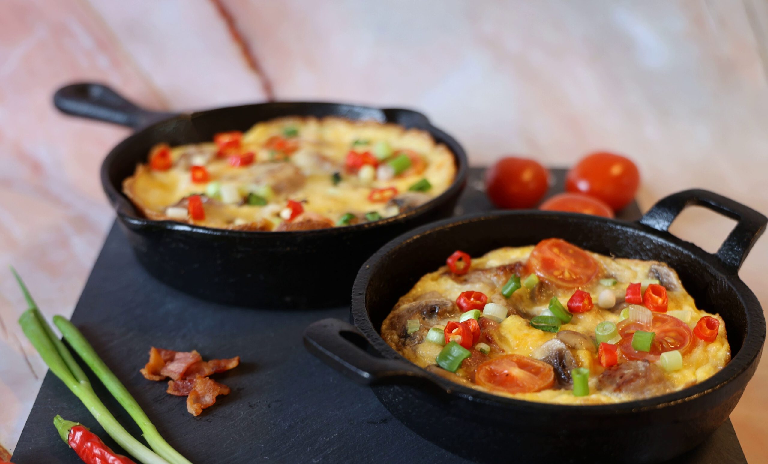 Eier und Bacon Close-up of delicious Italian frittata with fresh ingredients in a cast iron pan.