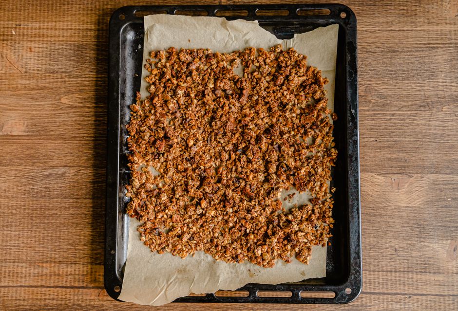 Low Carb Crunchy Müsli Freshly baked granola cooling on a baking tray lined with parchment paper.